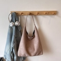 Minimalist tan suede oversized tote bag hanging on wooden rack with lifestyle accessories - Khaki