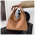 Dettaglio di una borsa hobo in pelle scamosciata marrone con tracolla regolabile e fibbie bronzo - Marrone