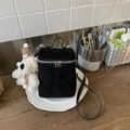 Detalle de un bolso cubo vintage de gamuza negra con un colgante de oso de peluche - Negro con colgante