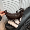 Bolso croissant de charol marrón oscuro con diseño plisado y detalles plateados - Marrón