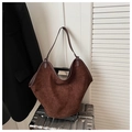 Dettaglio della borsa tote in pelle scamosciata marrone con apertura a V su valigia - Marrone