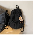 Detail of black nylon backpack featuring drawstring pocket and coffee cup plush charm - With Pendant / Black
