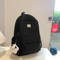 Minimalist black nylon backpack featuring a bear patch and a plush star pendant accessory - Large / With Pendant / Black