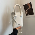 Schicke cremeweiße Beuteltasche mit Rundgriffen und gewebtem Anhänger im Casual-Stil - Gebrochenes Weiß