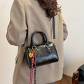 Schwarze glänzende Boston Tasche mit Herzanhänger und geflochtenen Anhängern auf der Schulter - Schwarz (Mit Anhänger)