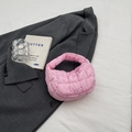 Mini-Puffertasche in Rosa mit Steppung und weichem Griff auf grauem Blazer-Hintergrund - Rosa