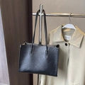 Fashionable black tote bag with wrinkled texture hanging on a minimalist metal rack - Black without Pendant