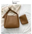 Dettaglio della borsa a tracolla marrone caramello e pochette su sfondo bianco - Marrone Borsa Grande e Borsa Piccola