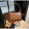 Dettaglio di una borsa a tracolla vintage marrone con manico largo e cinturino regolabile - caffè