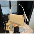 Dettaglio della borsa a patta quadrata crema con cuciture fini e texture in pelle liscia - Bianco Sporco