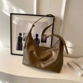 Minimalist dark brown hobo bag with leather texture and adjustable strap in a clean studio setting - Tan