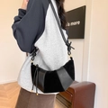Black leather and suede crescent crossbody bag with minimalist knotted shoulder strap - Black