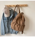 Detail showing brown nylon backpack with drawstring front pocket and denim jacket combo - No Pendant / Khaki