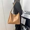 Classic khaki large capacity PU leather tote bag shown with shoulder strap on a model - Tan