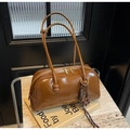Detalle de bolso bowling en cuero caramelo con cremallera dorada y nudo trenzado - Marrón (Con Colgante)