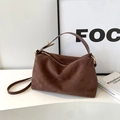 Detailed macro shot of brown suede Boston bag texture with high-quality gold hardware - Brown