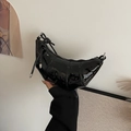 Minimalistische zwarte lakleren croissant crossbodytas met geplooide textuur en glanzende afwerking - Zwart