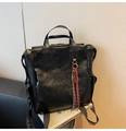 Detalle de mochila vintage de cuero negro con colgante de llave de latón y bolsillo lateral - Negro con colgante