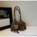 Close-up of canvas tote bag with leather trim and decorative plush bear charm - With Charm / Dark Brown