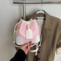Detail of pink and white bucket bag featuring pebble leather texture and gold buckle - Pink