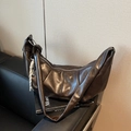 Deep brown crescent hobo bag in glossy leather with woven rope charm on textured books - Coffee with Pendant
