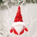Gnomo natalizio di peluche con cappello di paillettes rosse appeso a un ramo decorativo - Gnomo Rosso