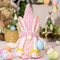 Roze paasgnome knuffel met konijnenoren en een blauw gestippeld ei in een feestelijke setting - Roze Vrouw (Met Ei)