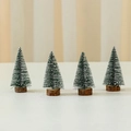 Set of four 10cm green mini cedar Christmas trees with snow spray and wood bases - Green