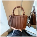 Detailed view of the brown pleated bucket bag showing dual circular handles and side mirror reflection - Brown