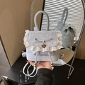 Light blue polka dot mini backpack with lace trim and heart pendant in hand-held shot - Blue