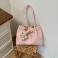 Dettaglio di una borsa shopper rosa con ciondolo a forma di orso su un mobile - Rosa con ciondolo