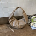 Détail macro du sac croissant en cuir PU kaki avec design plissé et poignée souple - Kaki