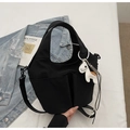 Primer plano de bolso tote negro con bolsillos frontales y colgante de caballo blanco - Con Colgante / Negro