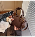 Détail du sac Boston en cuir marron foncé avec finitions dorées et breloque ourson - Avec Pendentif / Marron