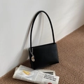 Minimalist black leather underarm bag with a decorative silver chain and bean pendant - Black with Pendant