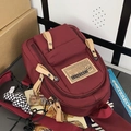 Dunkelrote Nylon-Umhängetasche mit Reißverschlussfächern und schwarz-weißem Schachbrett-Anhänger - Mit Anhänger / Rot