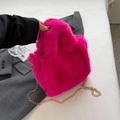 Détail du sac seau en fausse fourrure rose vif avec bandoulière chaîne dorée élégante - Rose rosé