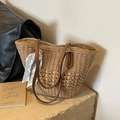 Natural straw tote bag with brown leather straps and floral scarf on a stone surface - Khaki