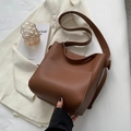 Sac seau minimaliste en cuir marron foncé avec une large bandoulière tendance - café