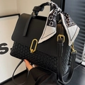 Elegante bolso negro trenzado con cierre dorado y bufanda decorativa en el asa - Negro