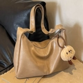 Minimalistische kameelbruine hobo schoudertas met pluche hanger op leren achtergrond - Met Hanger / Khaki
