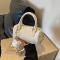 Creamy white Boston bag with leather texture and white pompom charm on a stone pedestal - Off-white With Pendant