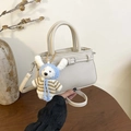 Minimalistische beige kiezellederen emmertas met een schattige witte konijnenhanger - Beige Met Hanger