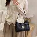 Retro black leather underarm bag with gold metal buckle shown on a model - Black