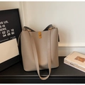 Close-up of litchi texture leather bucket bag with gold twist lock and shoulder straps - Khaki