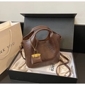 Detail der braunen Vintage-Eimertasche mit goldenem Anhänger in einer Geschenkbox - Kaffeebraun (Mit Anhänger)