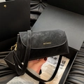 Dettaglio borsa a tracolla in pelle nera testurizzata con logo dorato e cinturino - Nero