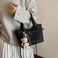 Classic black bucket bag with a cute white plush bear charm and sleek leather texture - Black