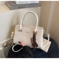 Détail du sac à main crème en cuir avec ferrures dorées et lettrage de la marque - Blanc Cassé Avec Pendentif