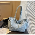 Dettaglio della borsa tote in tela celeste con stelle, tasca laterale e fiocco decorativo - Azzurro